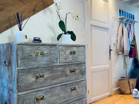 Verweerde ladekast met orchidee in de hal