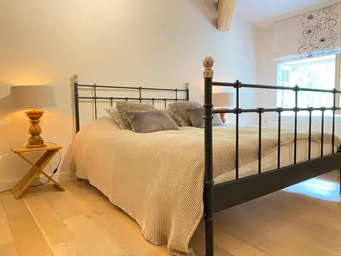 Tweepersoonskamer met smeedijzeren bed en natuurlijk licht