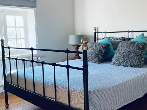Chambre au lit en fer forgé et coussins bleus