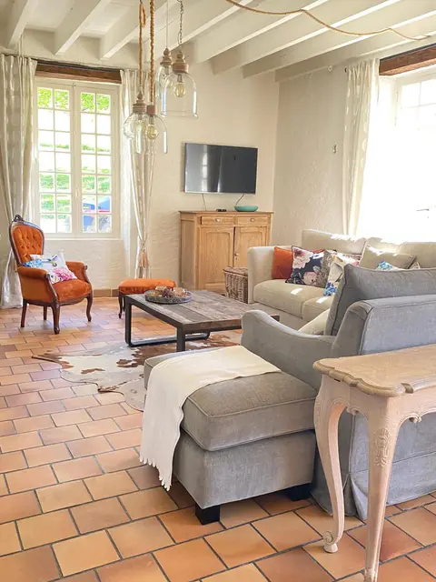 Woonkamer met zithoek, open haard en houten balken