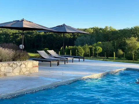 La piscine privée, ses transats et ses parasols, face à la verdure